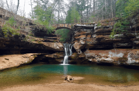 Rocky cove with small waterfall cascading into a pond below