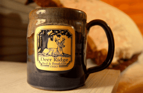 Blue ceramic pottery mug with square business logo on the front