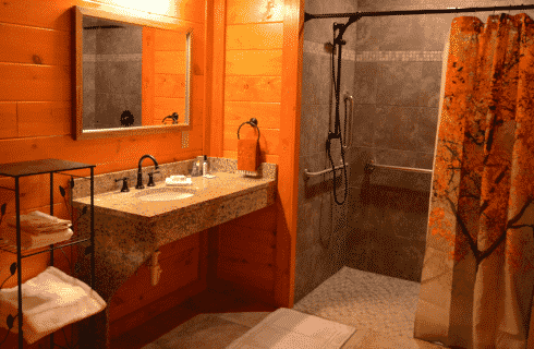 Spacious bathroom with granite vanity, natural wood walls and large tiled shower