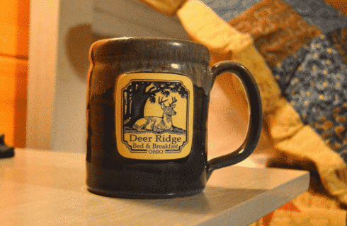Blue ceramic pottery mug with square business logo on the front