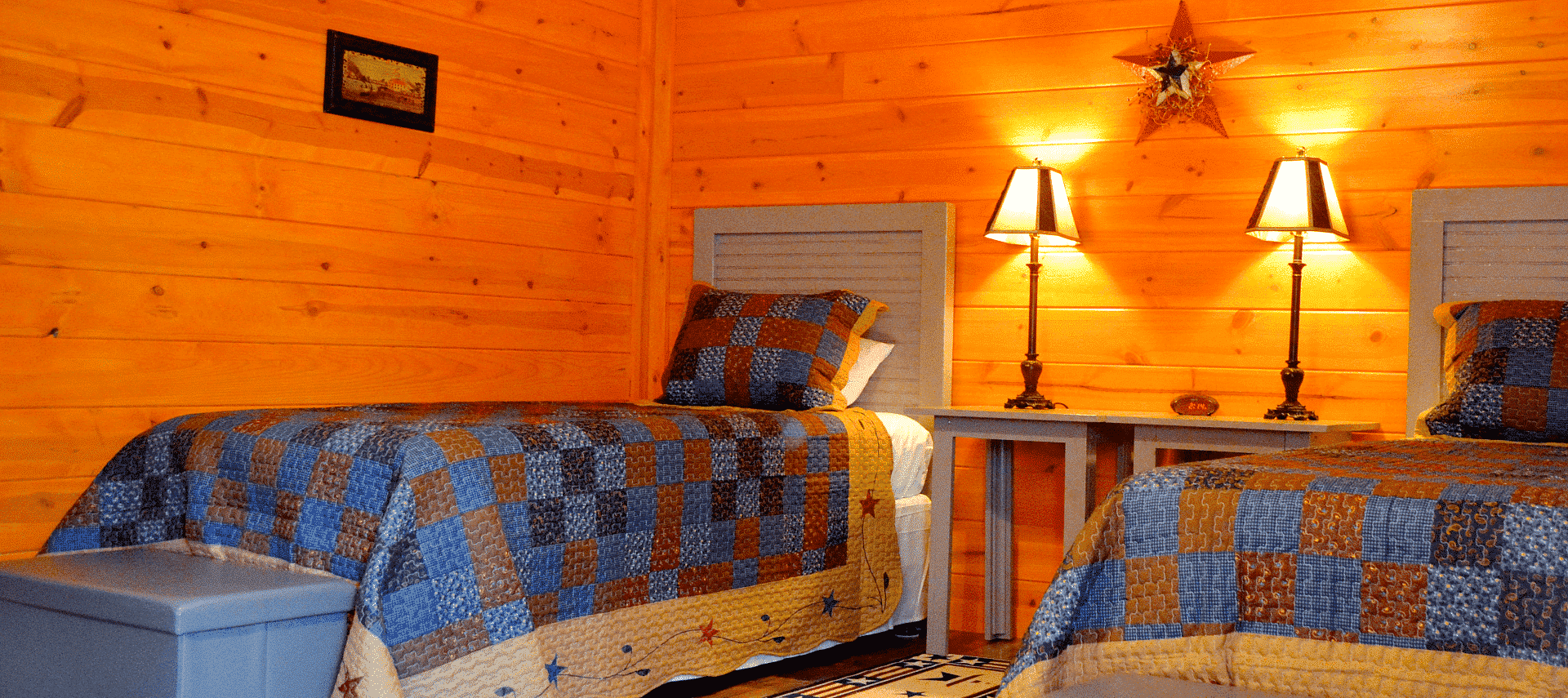 Two twin beds with beside tables and lamps in a log home bedroom with natural wood walls